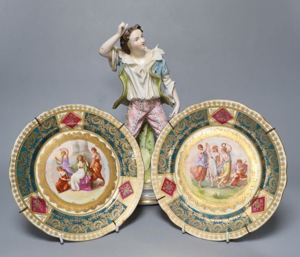 A 19th century French bisque figure, 32cm and two Vienna-style wall plates, 22cm